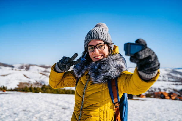 woman making selfie on snowy mountain - winter women zen like photography imagens e fotografias de stock