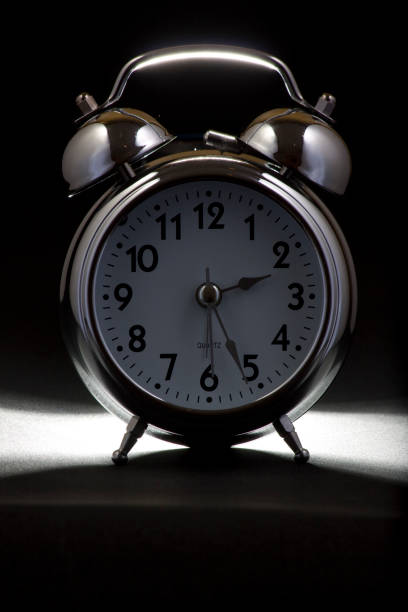 istock Nice old vintage chrome metal twin bell alarm clock on black background. 1281111142