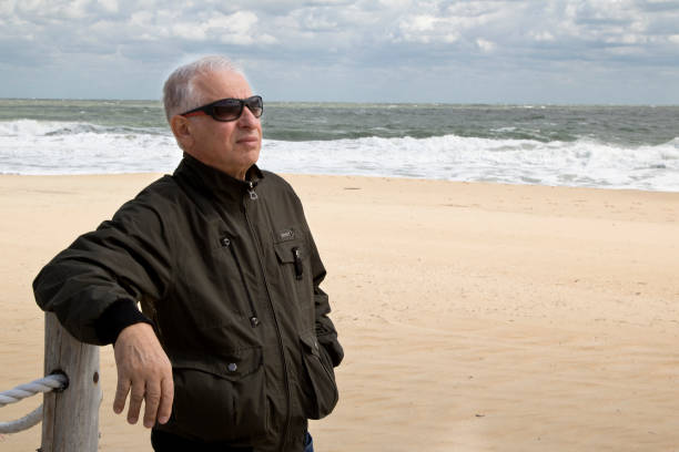 istock Senior man leaning on stanchion at Atlantic Ocean shoreline 1281111613