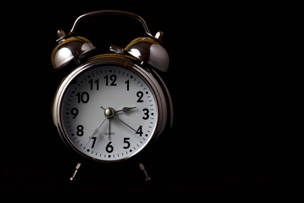 istock Nice old vintage chrome metal twin bell alarm clock on black background with copy space. 1281111654