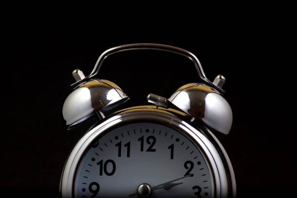 istock Nice old vintage chrome metal twin bell alarm clock on black background. 1281112383