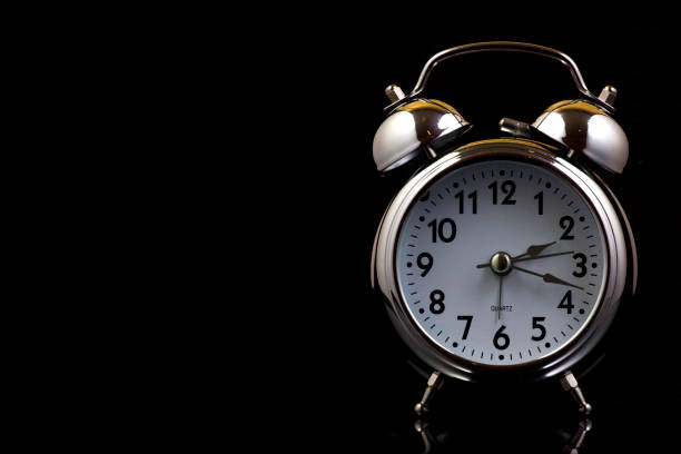 istock Nice old vintage chrome metal twin bell alarm clock on black background with copy space. 1281112486