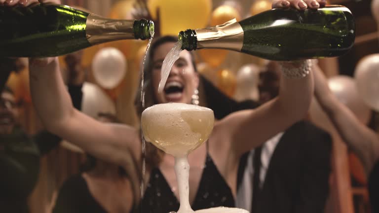 Woman filling champagne in glasses pyramid at party