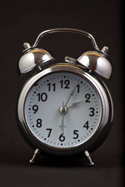 istock Nice old vintage chrome metal twin bell alarm clock on black background. 1281112932