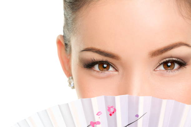 occhi di bellezza asiatici - truccatrice che guarda con il ventilatore - geisha japanese culture women japanese ethnicity foto e immagini stock
