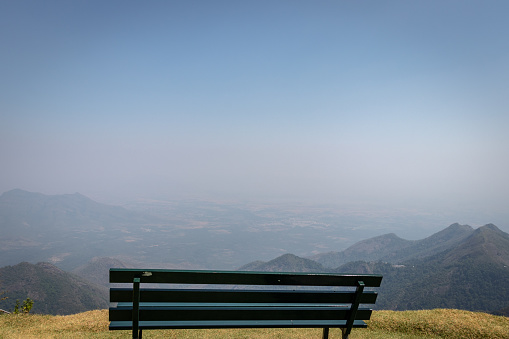 Isolated sitting bench with amazing landscape image is taken at coakers walk kodaikanal tamilnadu india.