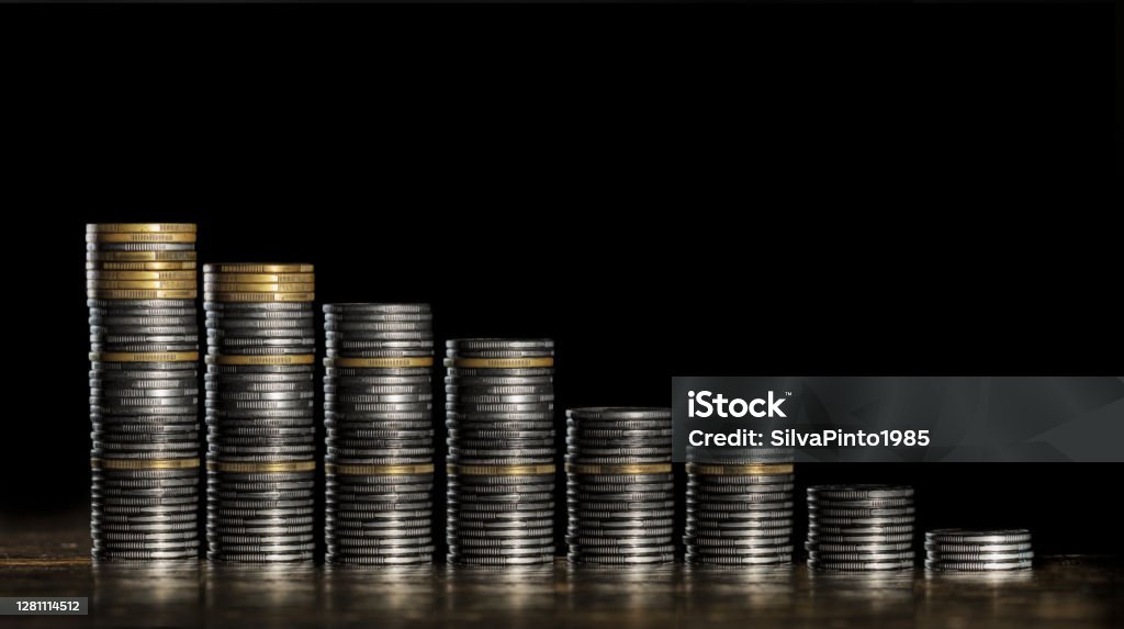 Coin stacks on a descending ladder, image alluding to the financial market. Accountancy Stock Photo