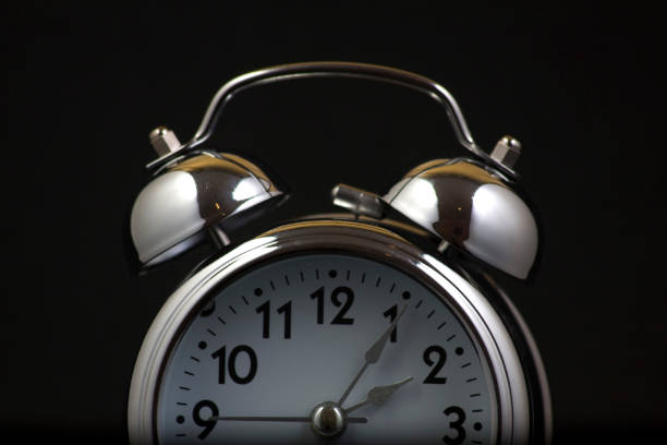istock Nice old vintage chrome metal twin bell alarm clock on black background. 1281114525