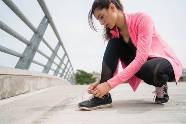 istock Athletic woman  tying her shoelaces. 1281114631