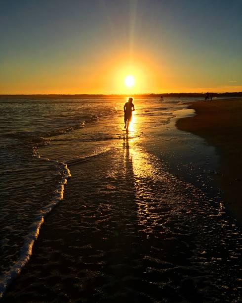 istock Running into the yellow glowing sunset at the beach motivational exercise 1281115717
