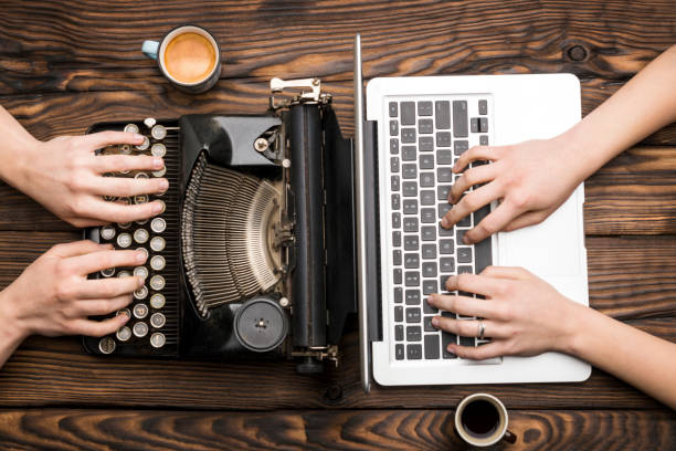 vecchia macchina da scrivere e laptop in uso - machine typewriter human hand typing foto e immagini stock