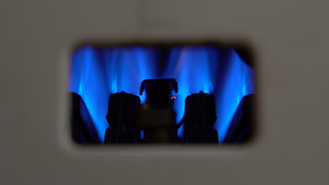 Gas water heater ignited by a wick. Blue fire close up