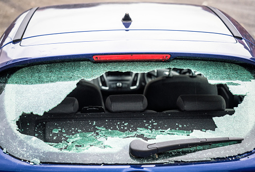 The rear windscreen of a small car smashed on the streets of a UK city.