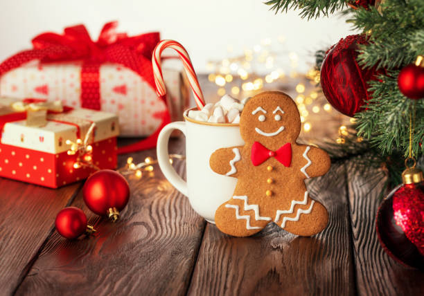 istock Christmas homemade gingerbread man, candy cane and cup with marshmallow on rustic wooden table. 1281120963