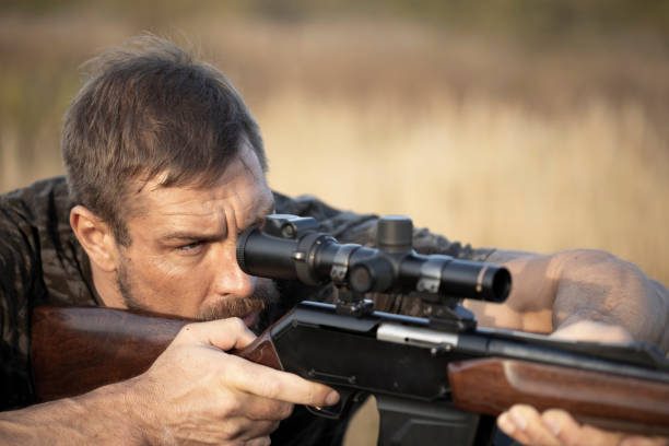 Close up image of male shooting rifle. Close up image of male shooting rifle. Image taken during big game hunting trip. Hunting period, autumn season open. 40 caliber bullets stock pictures, royalty-free photos & images