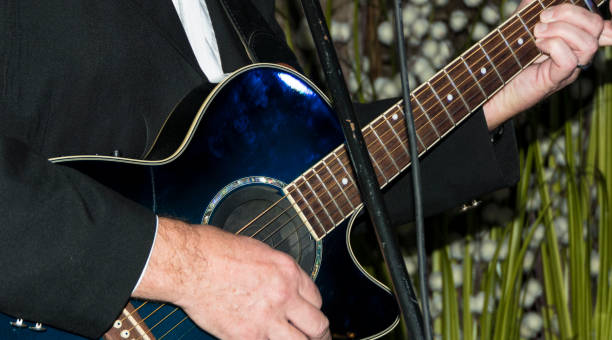 istock Musician singer with blue guitar right hand strikes the string 1281123818