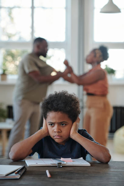 istock Annoyed little boy covering his ears by hands while his parents having row 1281124614
