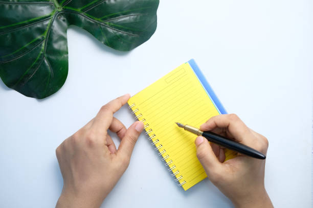 istock top view of women hand writing on notepad on white background 1281124780