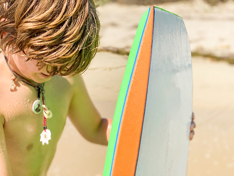 Child plays on a boogie board in the ocean of Santa Barbara, California.Santa Barbara County, at 2:00pm.