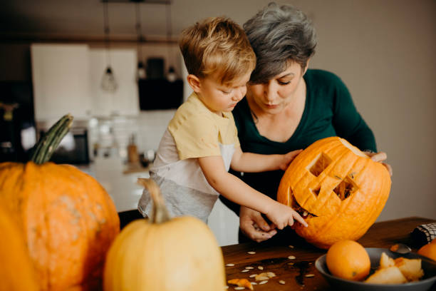 istock Grandma helps her grandson cut pumpkin 1281128722