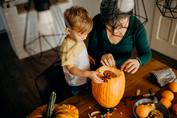 istock Grandma helps her grandson cut pumpkin 1281128830