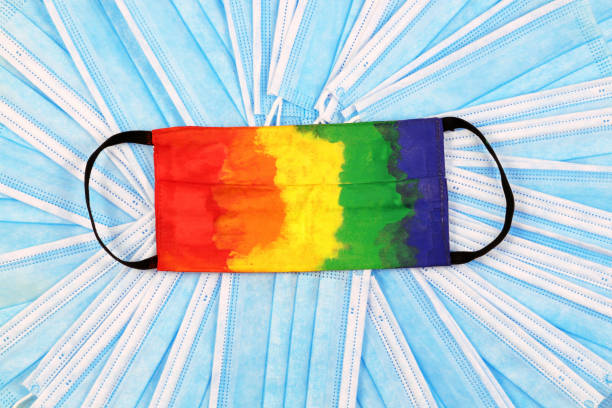 istock Multicolored protective mask. Disposable medical mask painted with gouache in rainbow colours. Many disposable medical protective masks, top view. Healthcare and medical concept. 1281130171