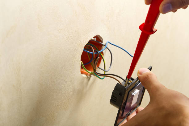 istock electrician installing light switch on painted wall with screwdriver. Man installing light switch after home renovation. 1281130667
