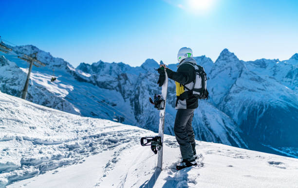 Snowboarder ready to ride Snowboarder standing on the hill and getting ready for a ride top of ski mountain stock pictures, royalty-free photos & images