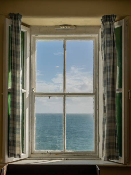 istock Sea View Out an Old Irish Window, with Shutters and Curtains 1281132722