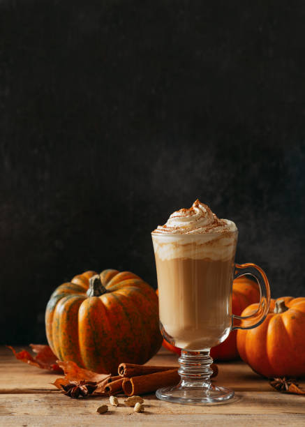 istock Spice pumpkin latte with cream foam, cinnamon stick, leaf and orange pumpkins 1281133004