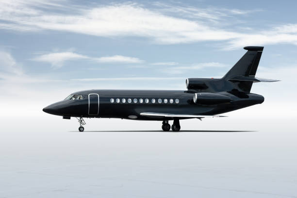 istock Modern black business jet isolated on light background with sky 1281133193