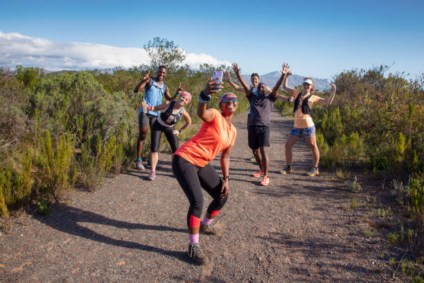 um grupo multiétnico de caminhantes tirando uma selfie em grupo. - running jogging footpath cross country running - fotografias e filmes do acervo