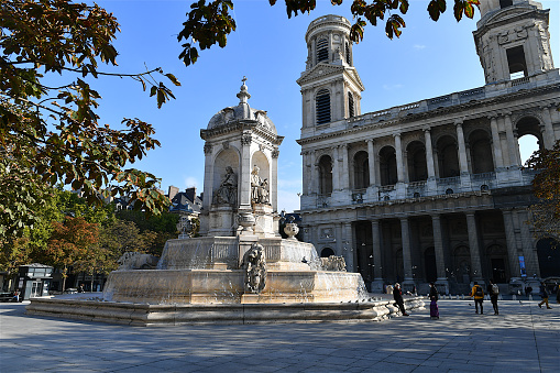 Paris, France-10 18 2020:People by the fountain on the Saint-Sulpice square in Paris.Saint-Sulpice is a Roman Catholic church in Paris, France, in the Odéon Quarter of the 6th arrondissement. It is the second largest church in the city after Notre Dame Cathedral.