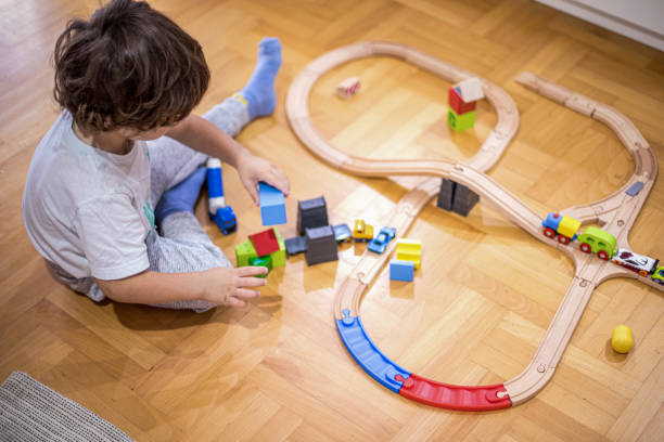 istock Beautiful little boy playing with a railroad train toy. 1281136240