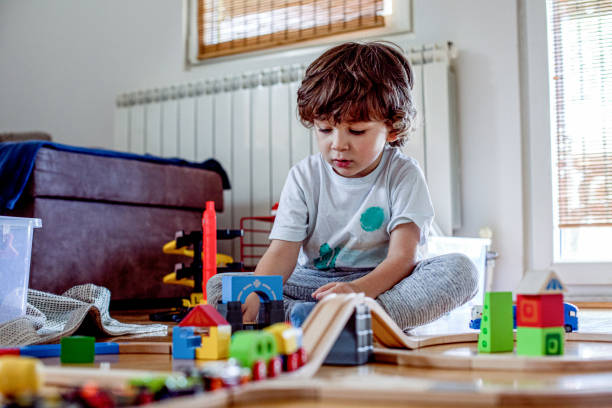 istock Beautiful little boy playing with a railroad train toy. 1281136303