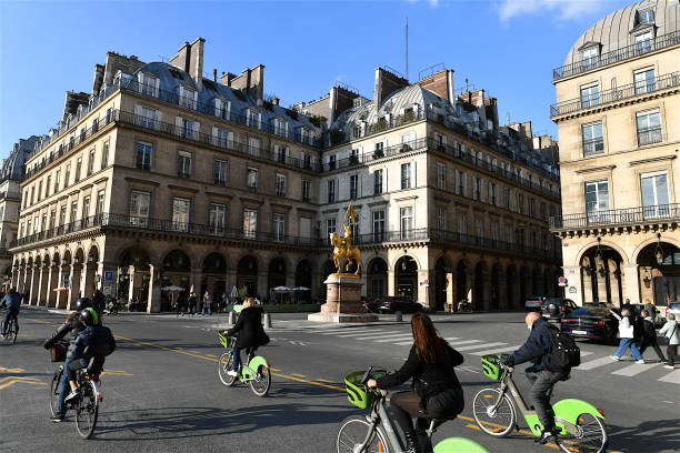 The Place des Pyramides, Paris, France. Paris, France-10 19 2020:People riding bicycles on the rue de Rivoli in Paris, passing by the equestrian statue of the French heroine Joan of Arc (1412 - 1431), which is prominently located in the Place des Pyramides. place des pyramides stock pictures, royalty-free photos & images