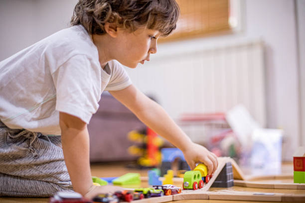 istock Beautiful little boy playing with a railroad train toy. 1281136384