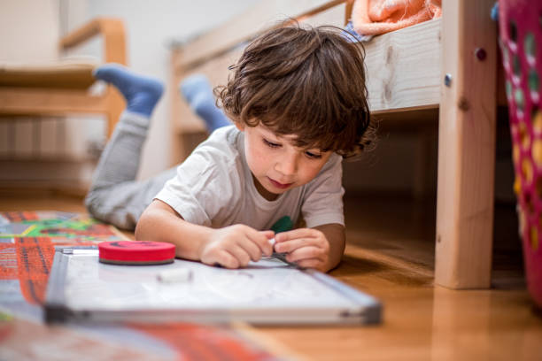 istock Beautiful toddler boy drawing on the white board. 1281137072