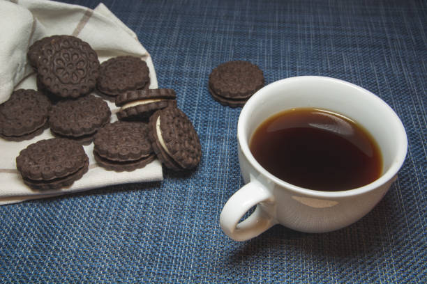istock Coffee in a cup and cookies on a blue background 1281137177