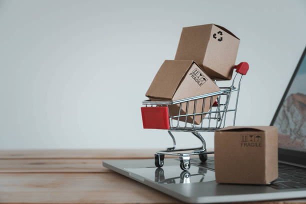 Close up Paper cartons with a shopping cart or trolley on a laptop. Ideas about customers order buy from retailer sites via the internet website.Online shopping,ecommerce and delivery service concept cierre los cartones de papel con un carrito de compras o un carrito en un portátil. ideas sobre los clientes piden comprar en los sitios de minoristas a través del sitio web de internet. concepto de servicio de compras, comercio electrónico y entrega en
