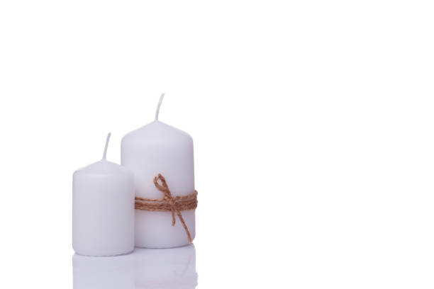 istock two white candles of different sizes, one wrapped in jute rope, isolated 1281140555