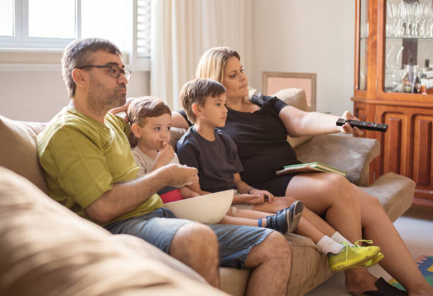 istock Family watching television together at home 1281140995