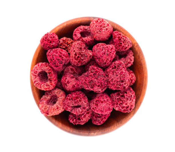 istock Dried raspberry isolated on white background. Dehydrated raspberry in wooden bowl. Top view. 1281141084