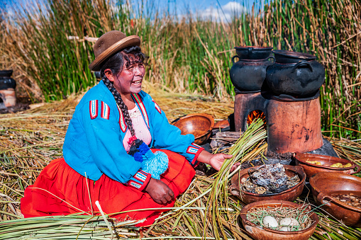 Young woman grinding corn.  Maize.  Traditional Mexican culture.