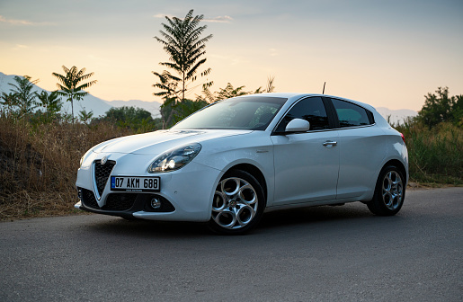 Antalya, Turkey - August 11, 2020: 2018 model white color Alfa Romeo Giulietta is parked at the city street at sunset