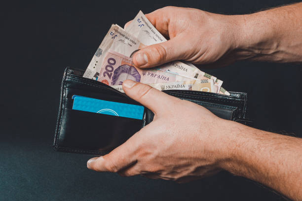 hryvnia ucraniana en un bolso negro, un hombre tiene en sus manos. - ukraine hryvnia currency paper currency fotografías e imágenes de stock