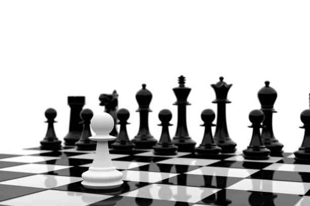 istock White pawn stands alone against group of black chess pieces 1281146523