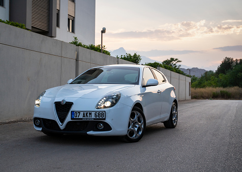 Antalya, Turkey - August 11, 2020: 2018 model white color Alfa Romeo Giulietta is parked at the city street at sunset