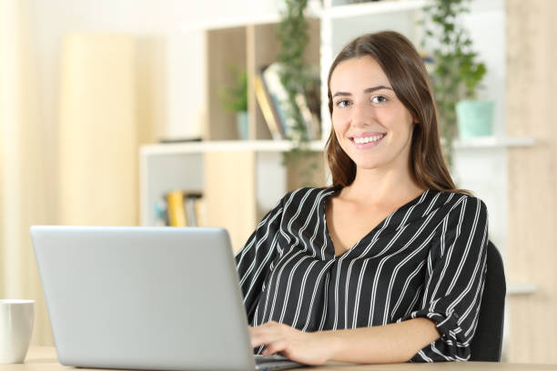 istock Happy woman posing with a laptop at home 1281149270