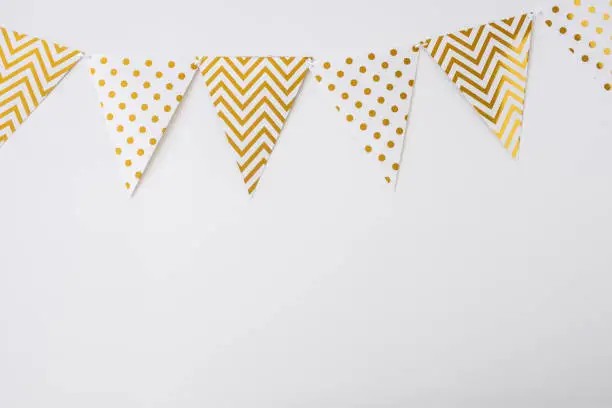 Photo of White and gold bunting flags isolated on white background